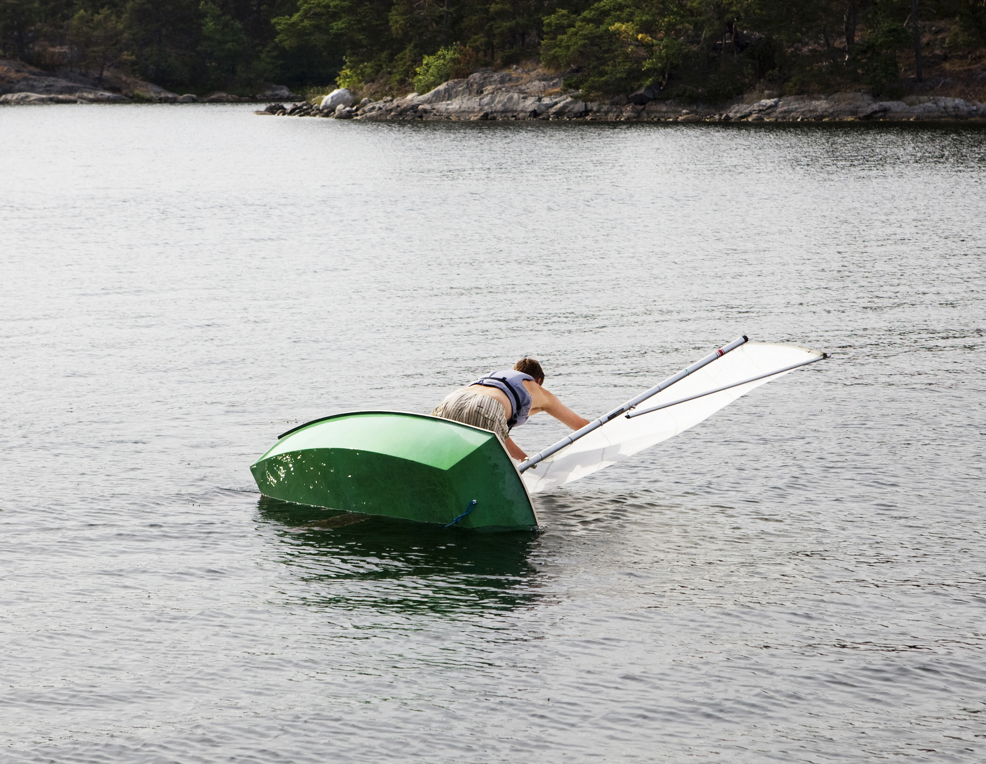 Man and dinghy falling into water