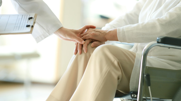 Doctor examining patient in wheelchair