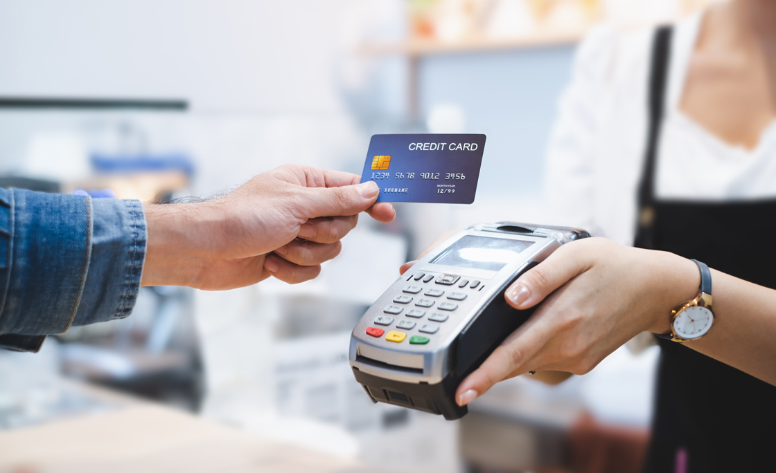 Cropped Hand Giving Card To Woman In Shop