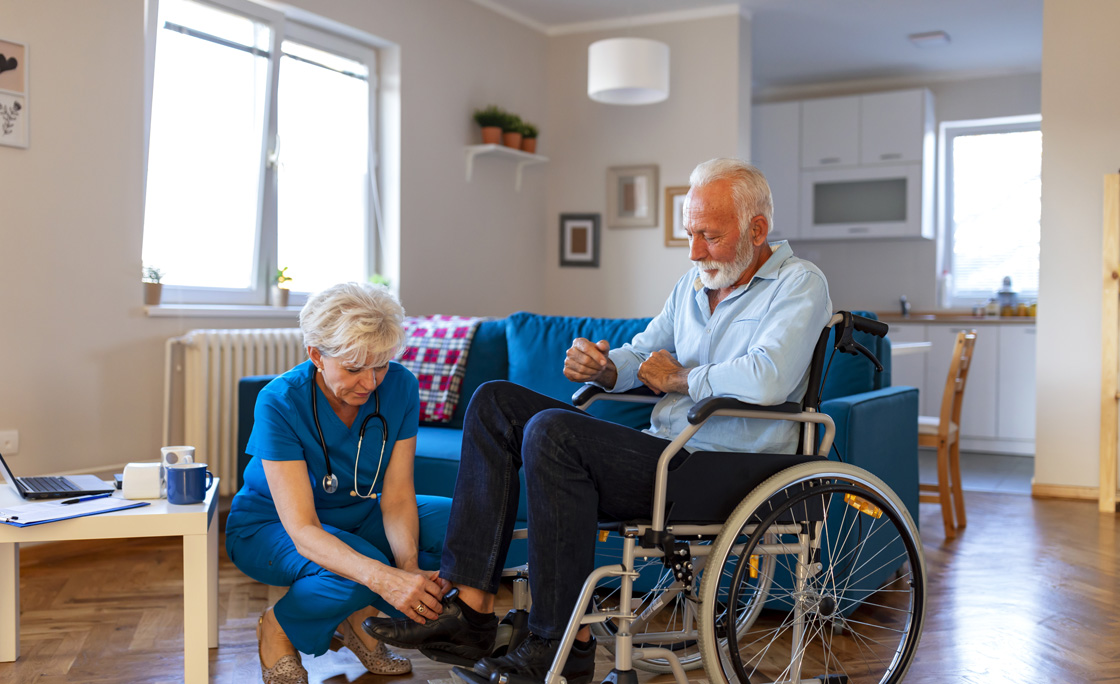 Nurse helping senior man on wheelchair