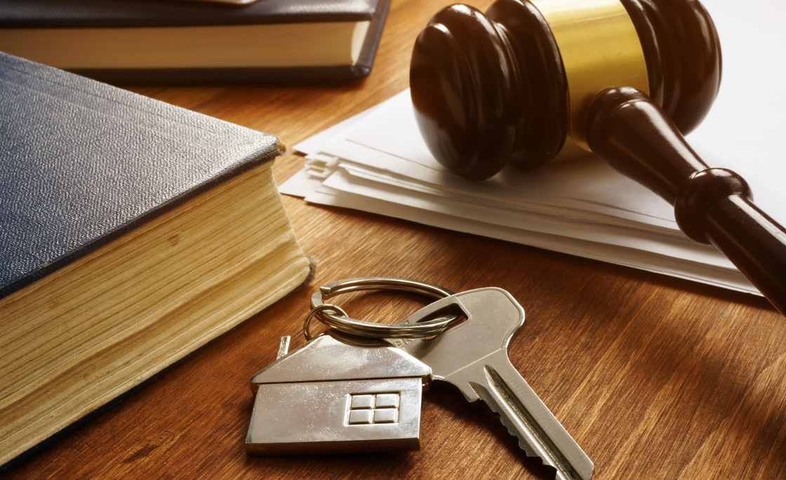 Property law concept. Key from real estate and gavel.