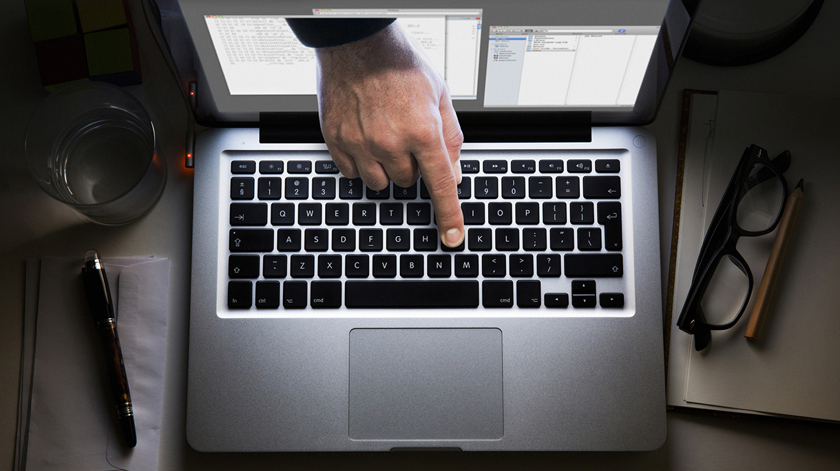 Hand appearing from laptop screen, touching the keyboard