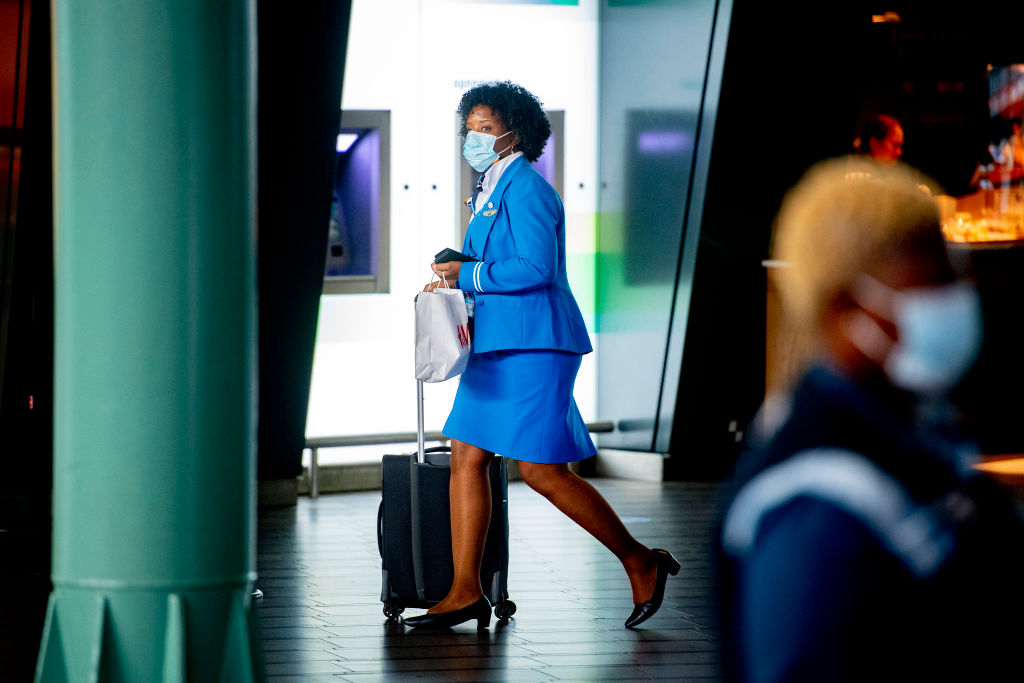 A KLM stewardess with her luggage walks at the airport.
It