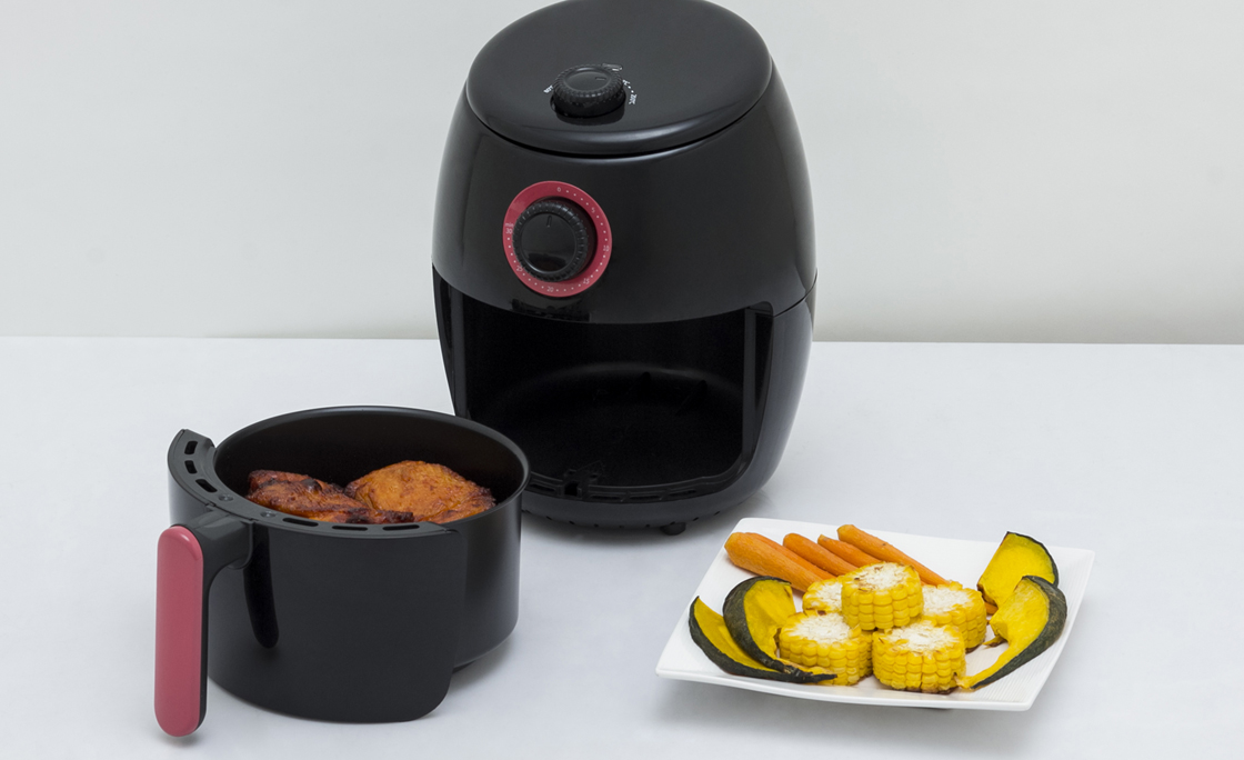 Air fryer machine with chicken and vegetables