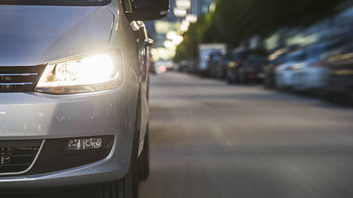 Car driving on urban street, low angle view