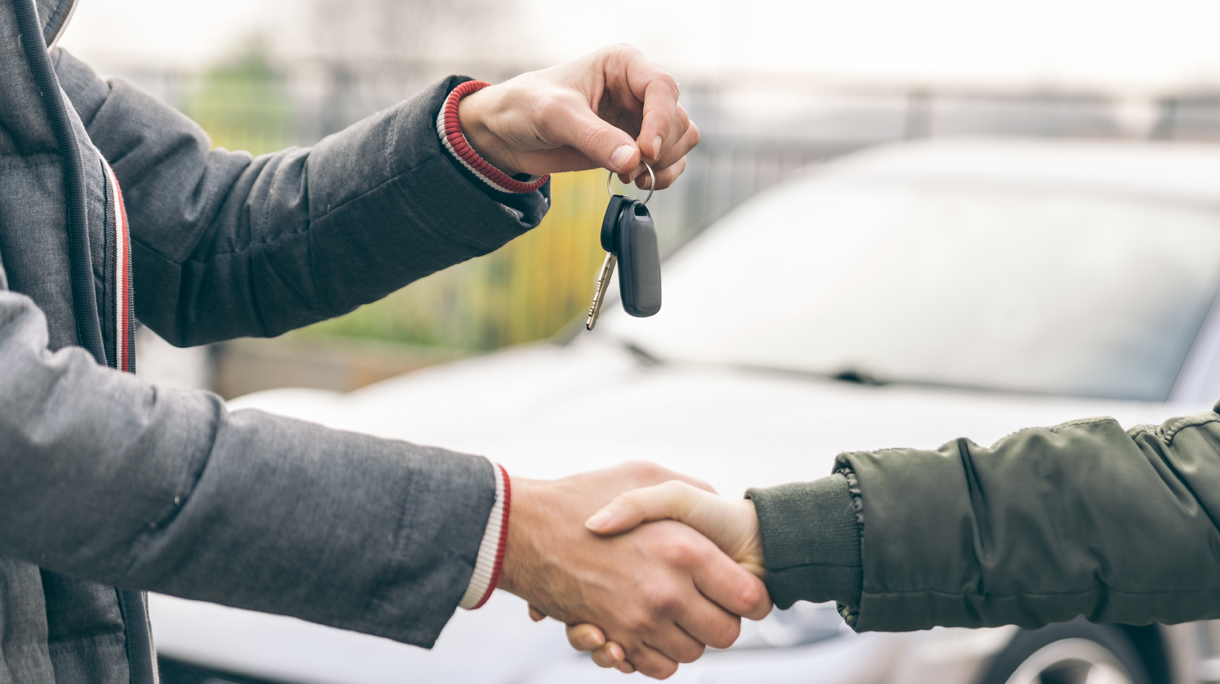 Two people reaching an agreement about a car sale
