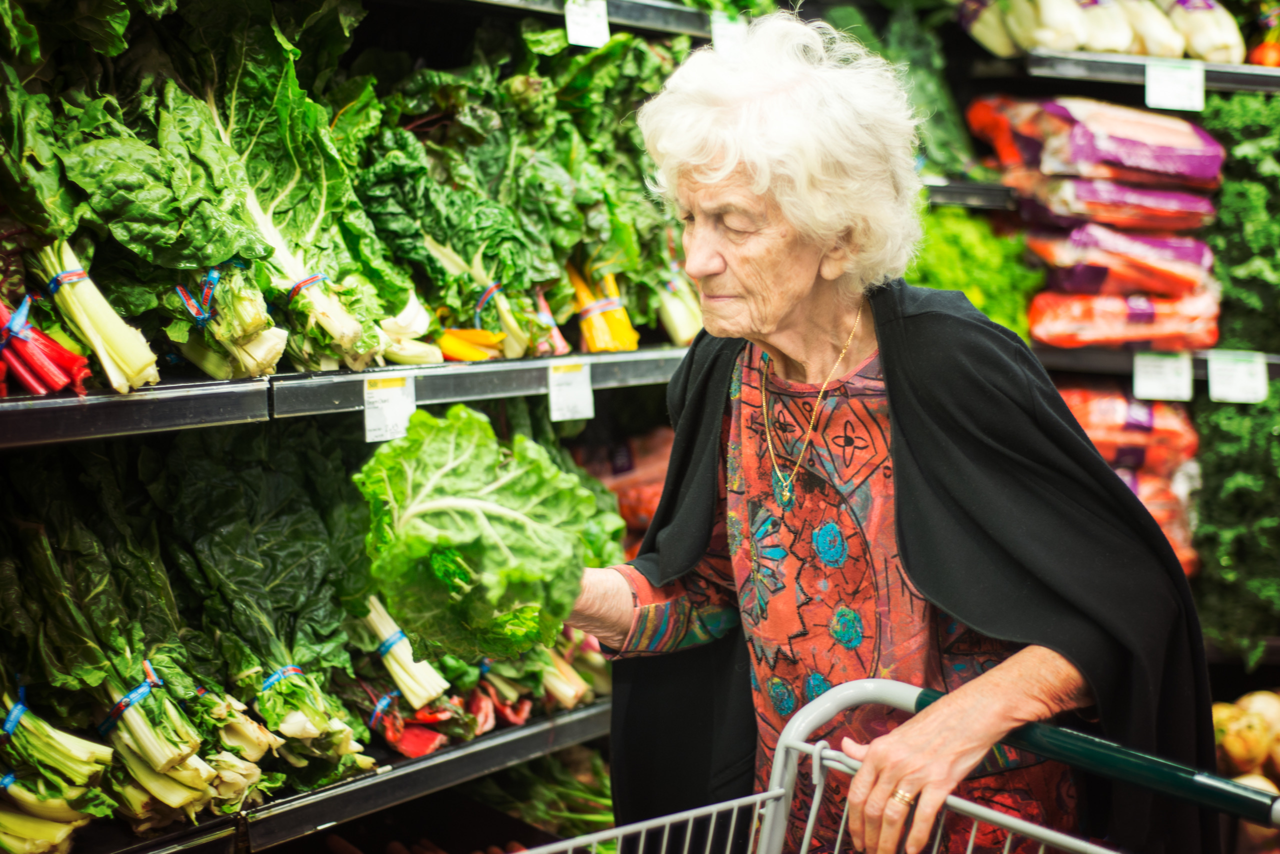 Senior Woman Shopping for Vegetables in Grocery Store