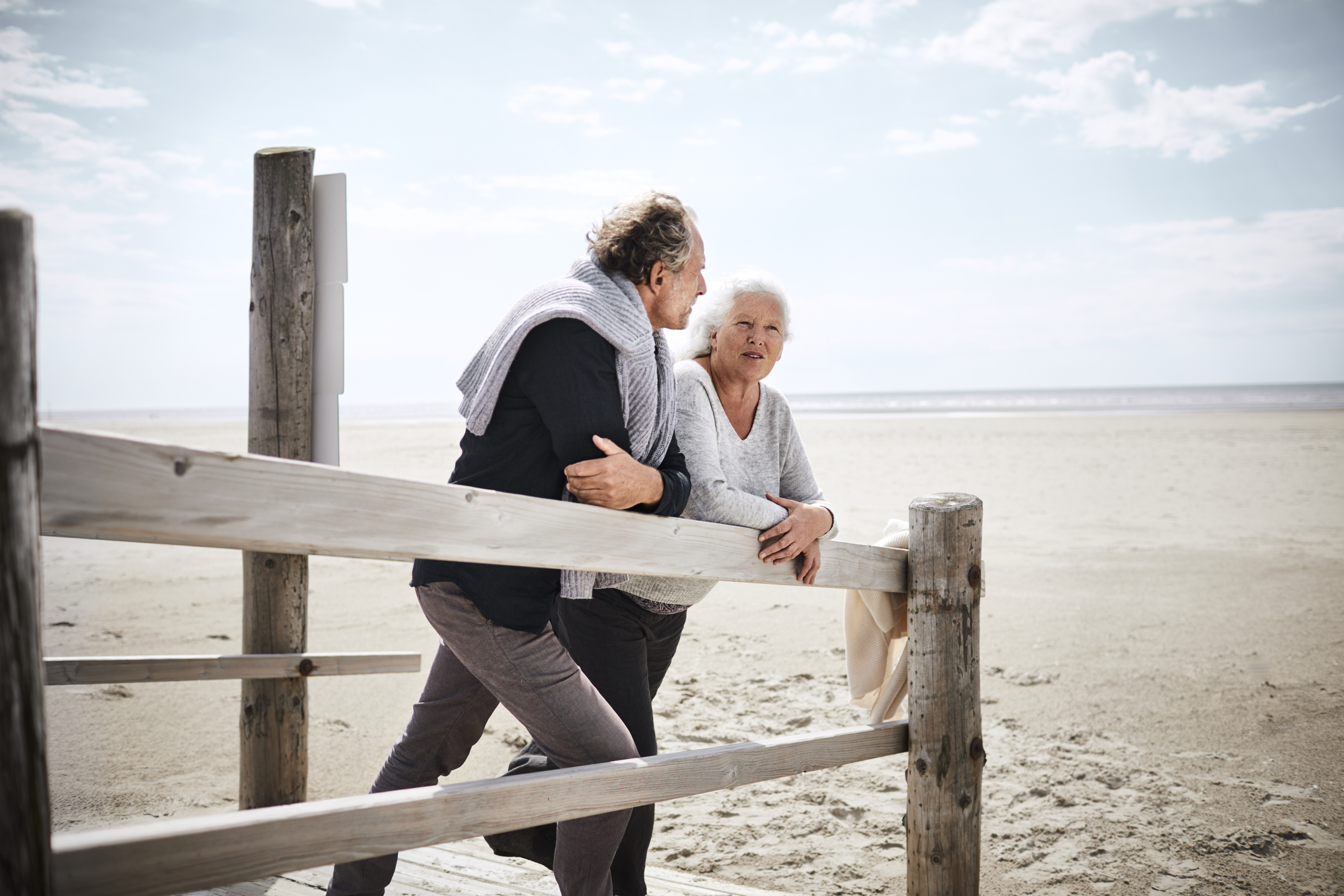Senior couple standing on boardwalk on the beach