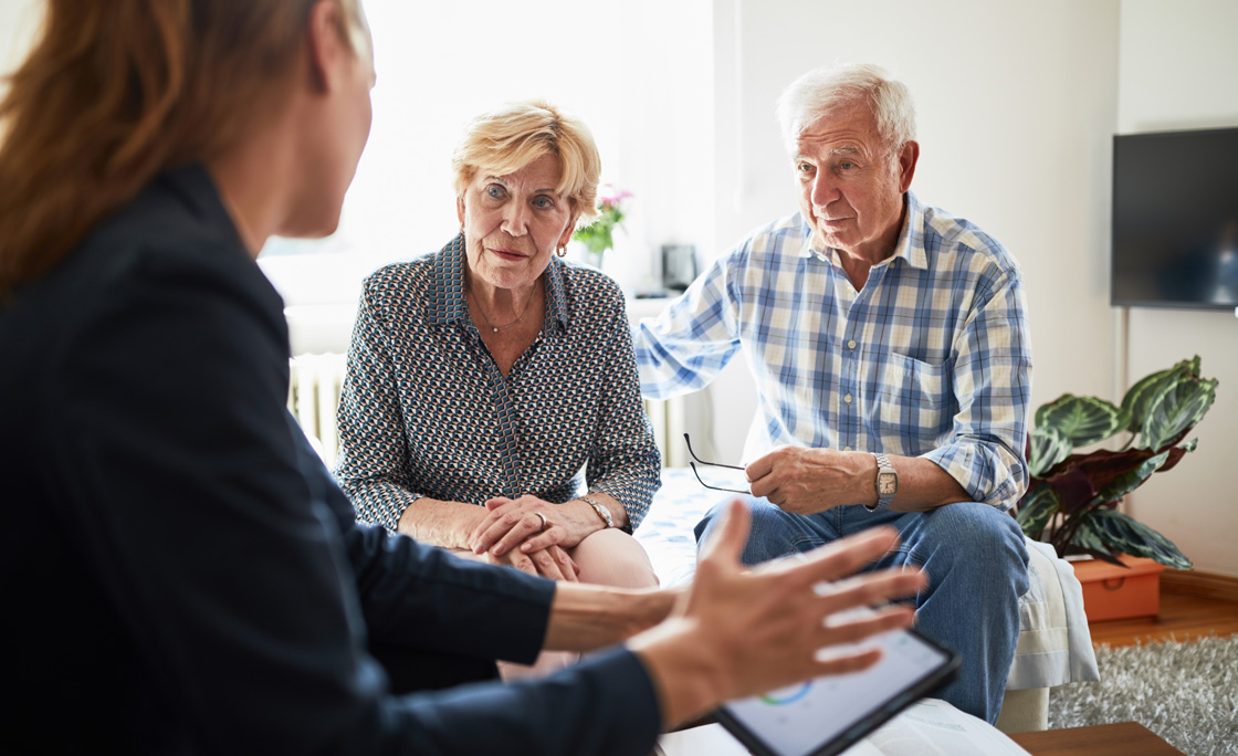Elderly couple at home in meeting with financial advisor