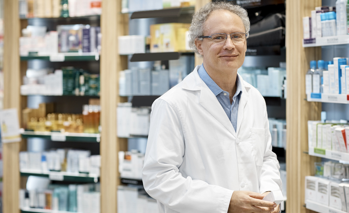 Portrait of smiling pharmacist holding medicine