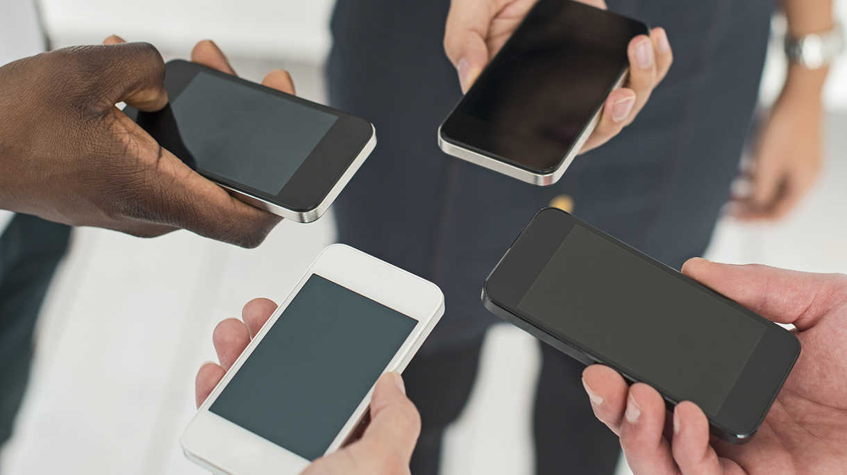 Four people with smartphones exchanging data