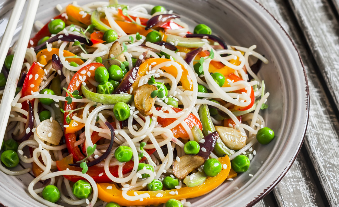 Rice noodles with vegetable stir fry on the ceramic plate