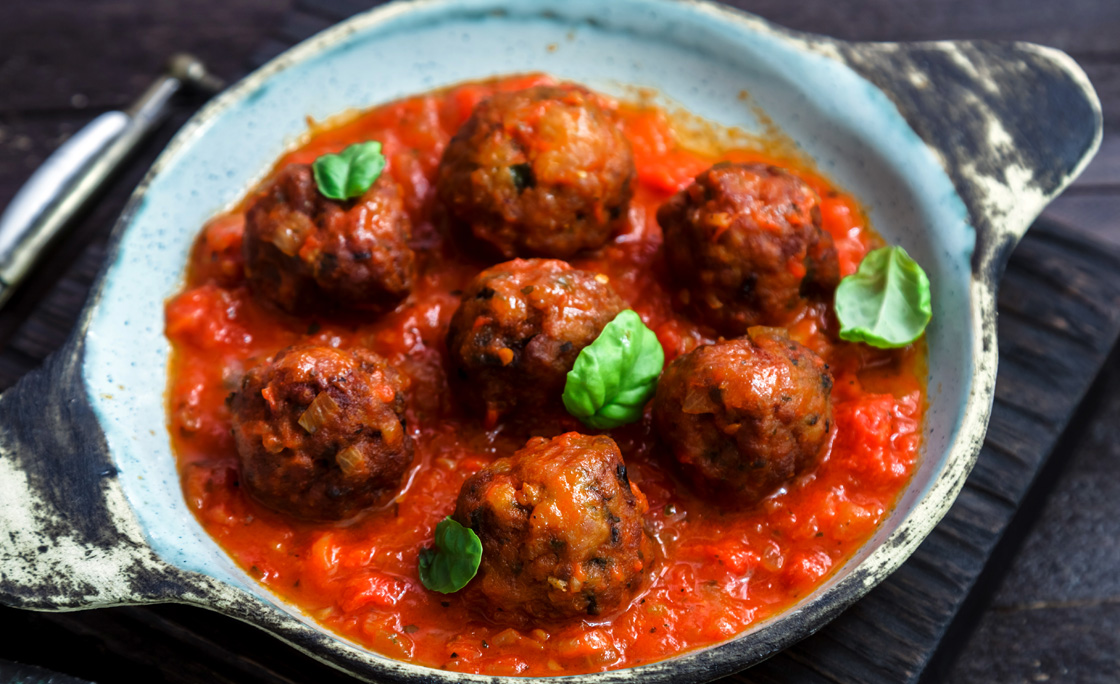 Meatballs with tomato sauce on a ceramic pan. Close view, rustic style