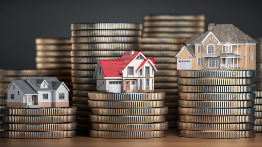 Houses of different size with different value on stacks of coins. Concept of  property, mortgage and real estate investment.