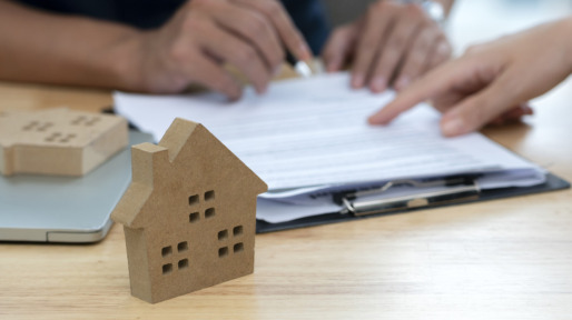 Customer signing a real estate contract in real estate agency.