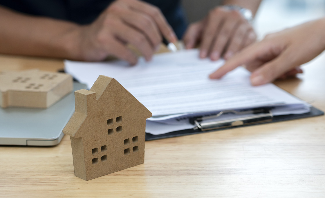 Customer signing a real estate contract in real estate agency.