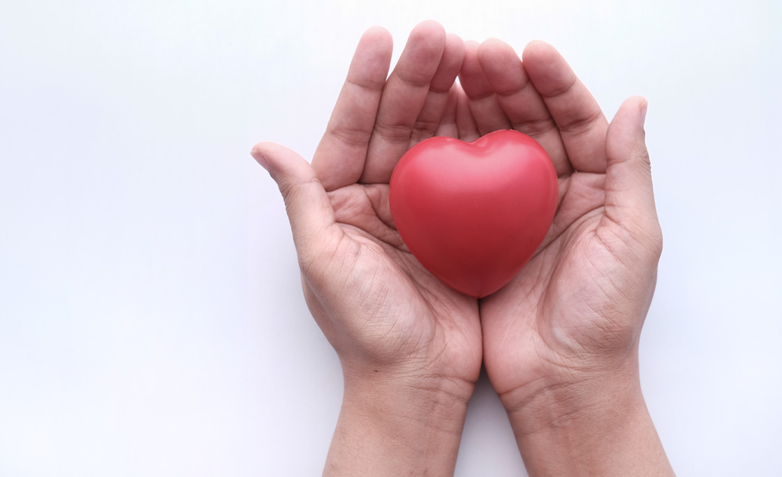 Woman Holding Red Heart In Hands On Wooden Table