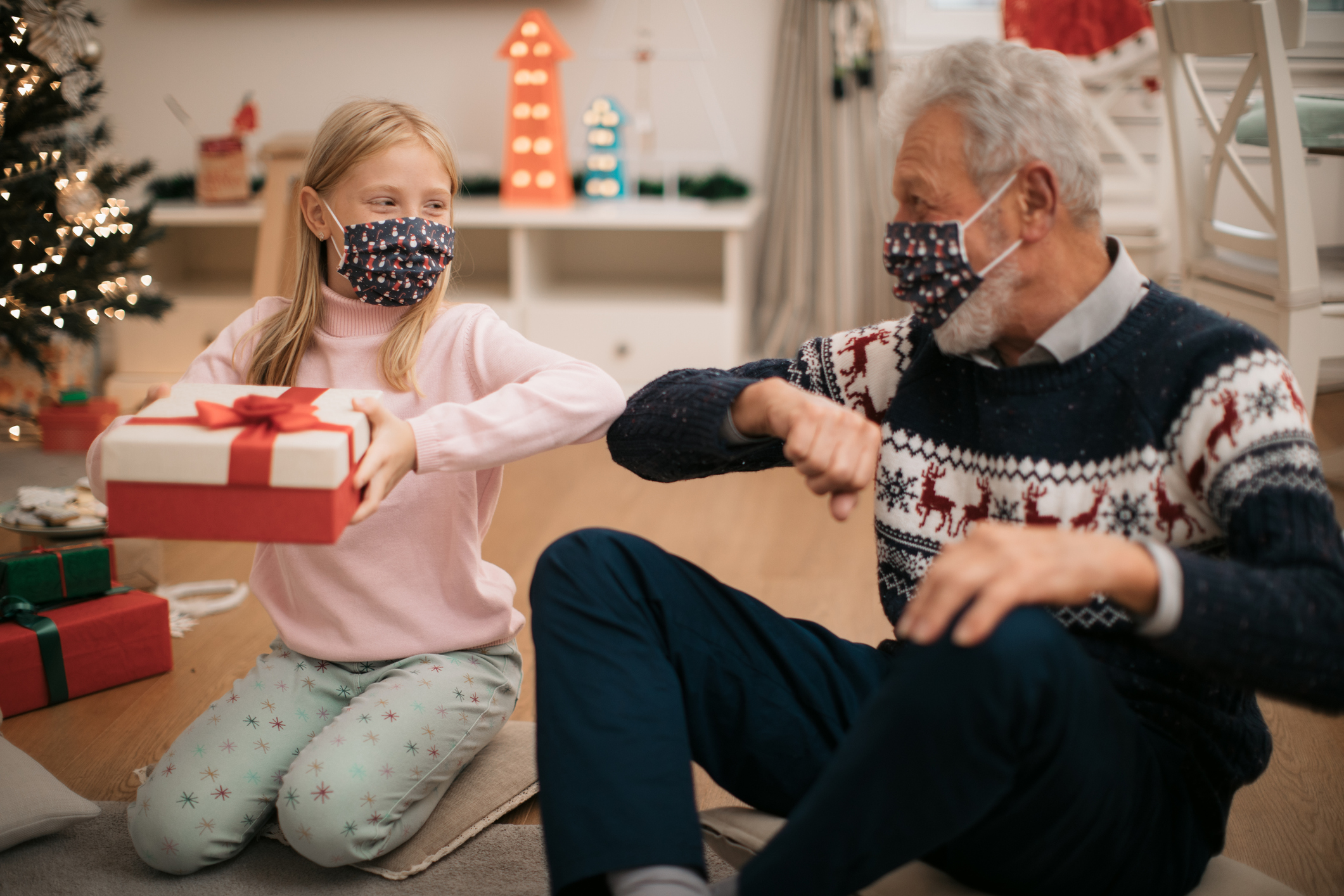 Happy Caucasian family enjoying the winter holidays at home, elbow bump greetings