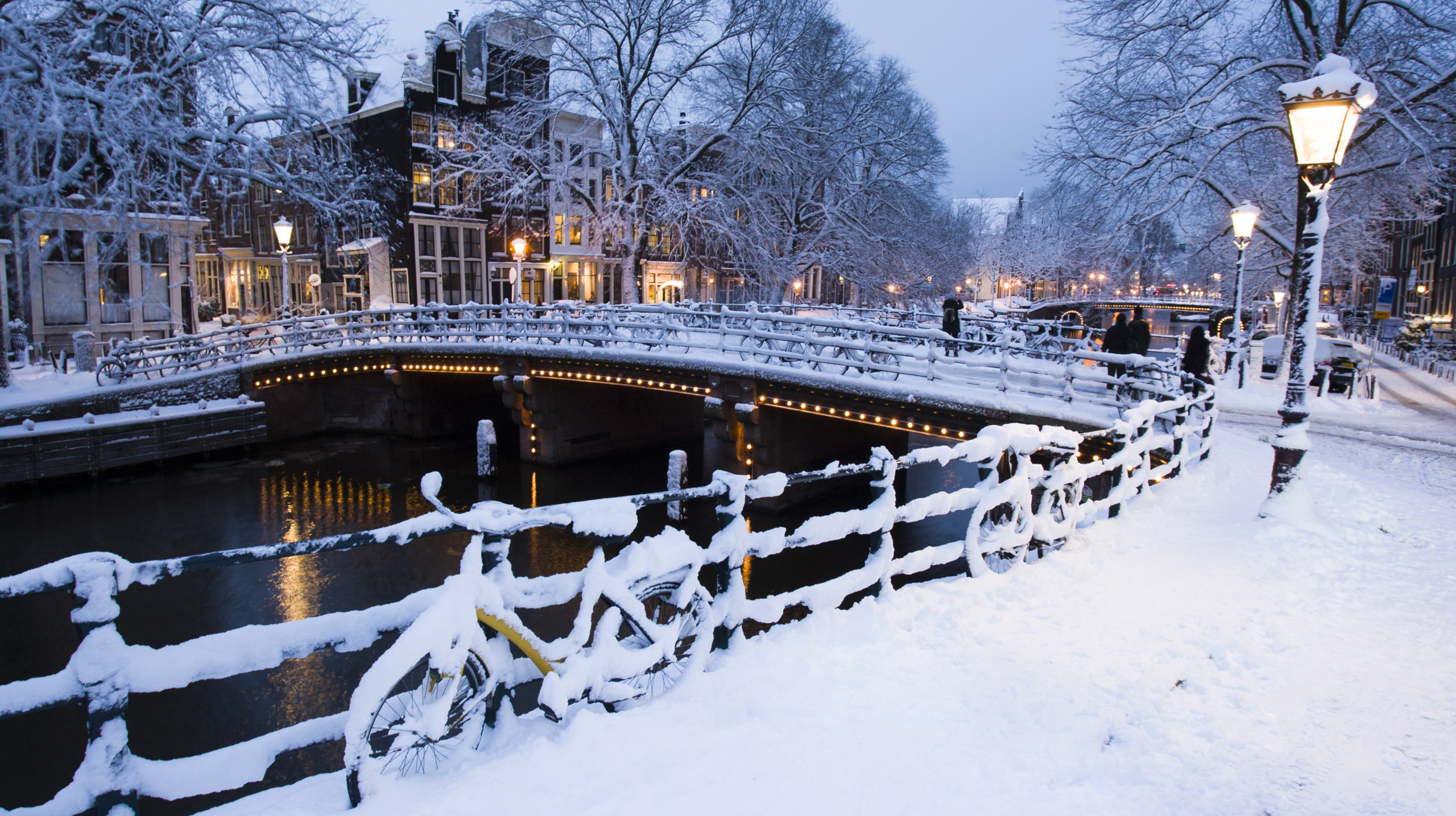 Evening light on the snow covered streets and canals of Amsterdam, the Netherlands.