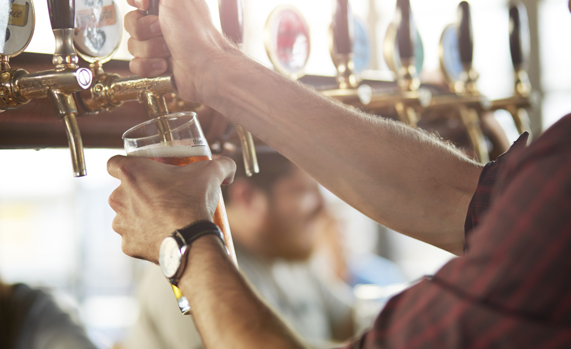 Close-up of bartender making cask beers at bar