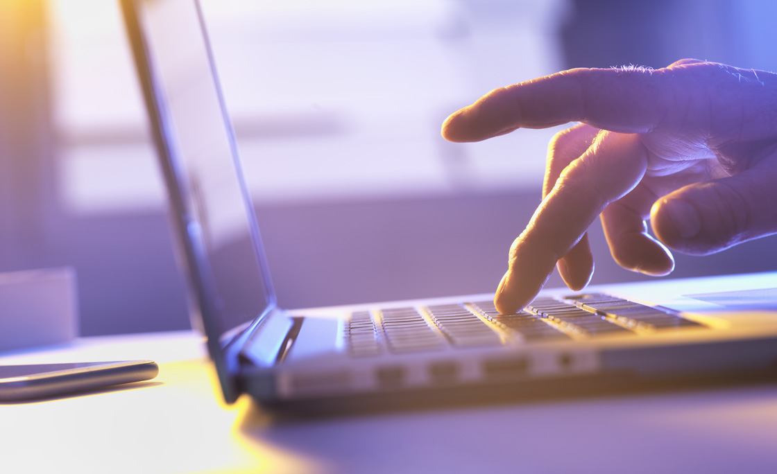 Man working online at a laptop computer