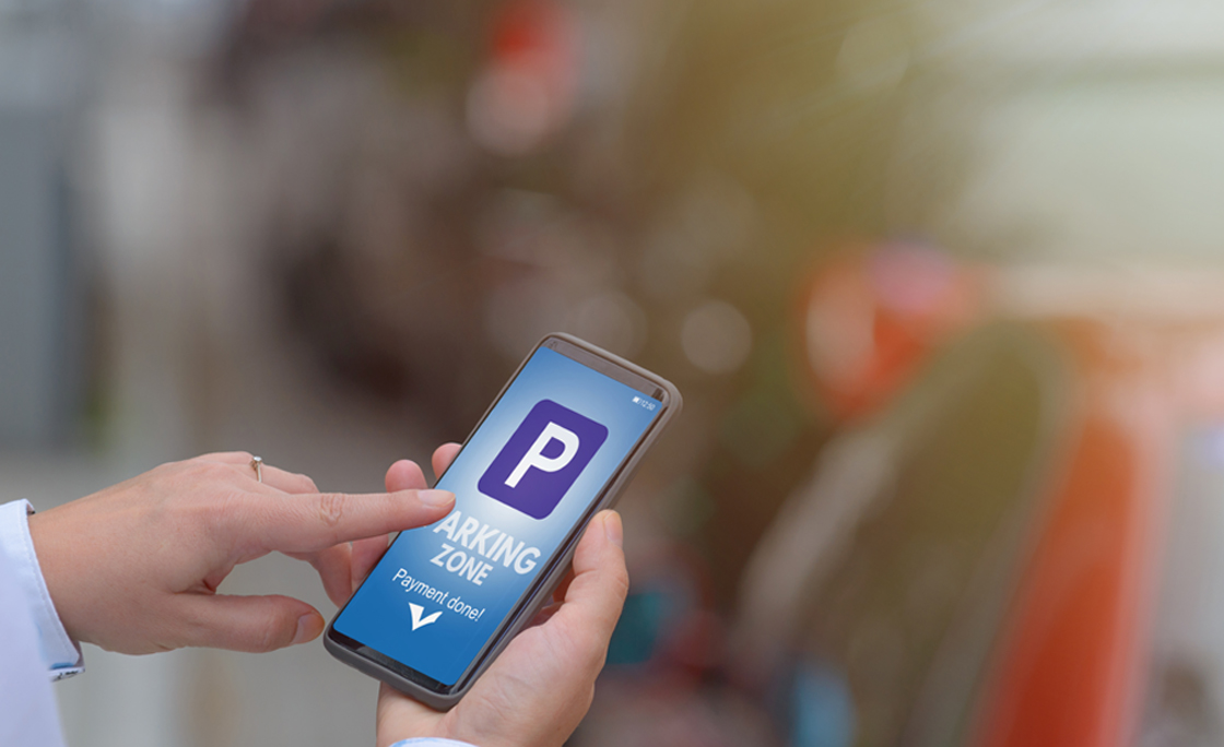 Woman using smartphone app to pay for parking