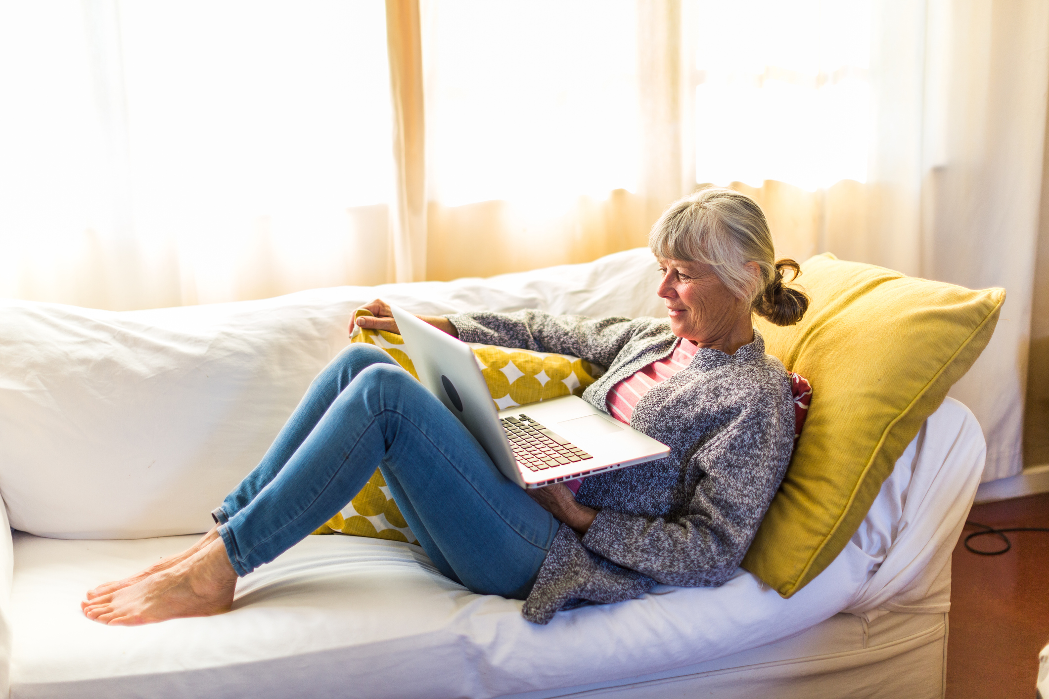 Senior woman skyping friends on her laptop computer