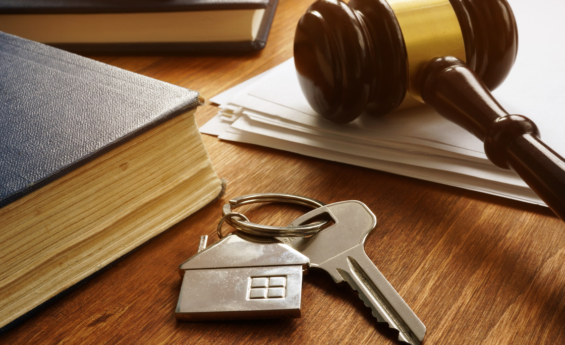 Property law concept. Key from real estate and gavel.