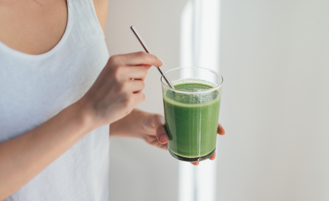 Young Woman Drinking Green Juice For Cleanse Diet
