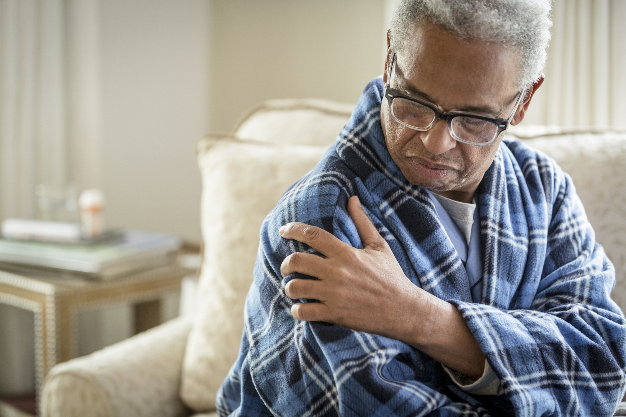 Senior African American man rubbing his shoulder