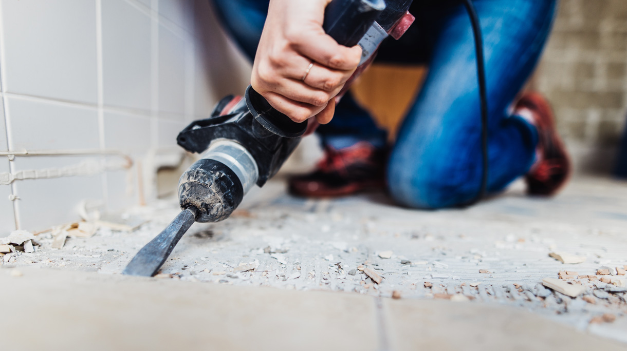 Woman removing old tiles.