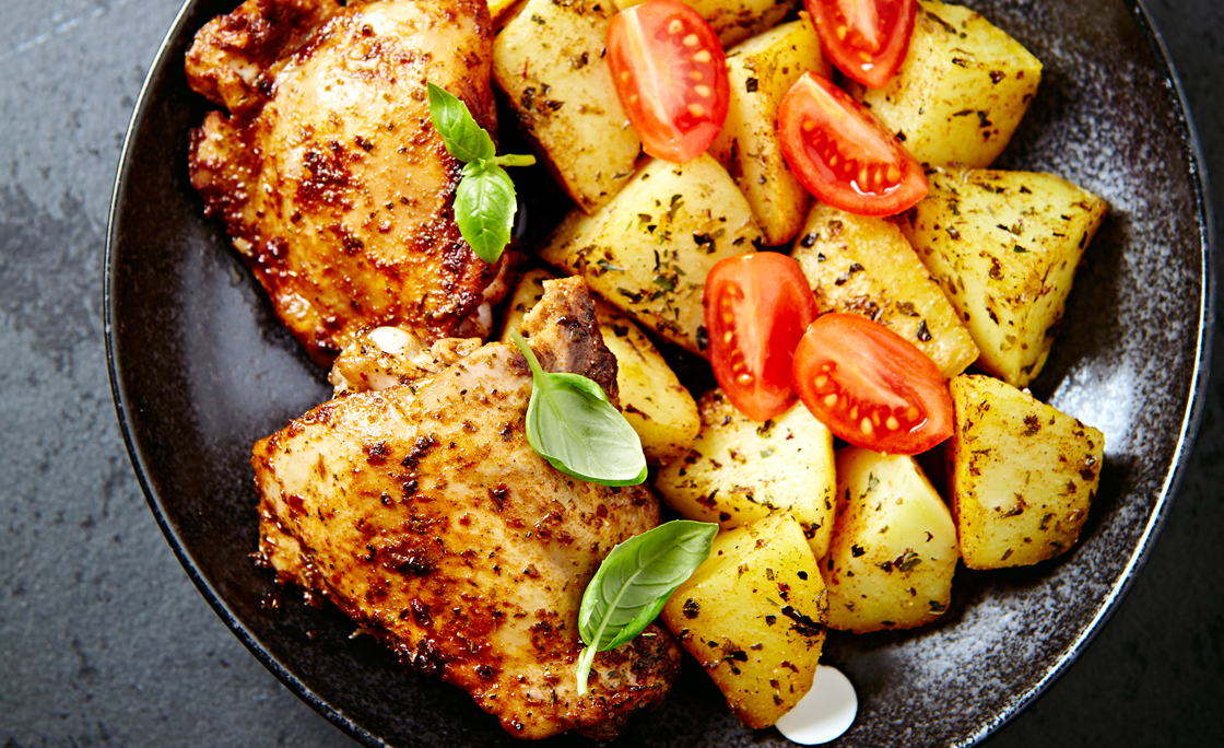 Roasted chicken with baked potatoes on a plate