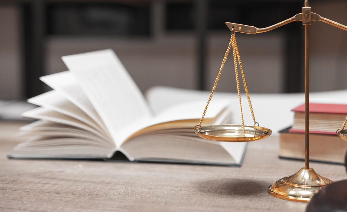 Close-Up Of Weight Scale And Gavel On Table