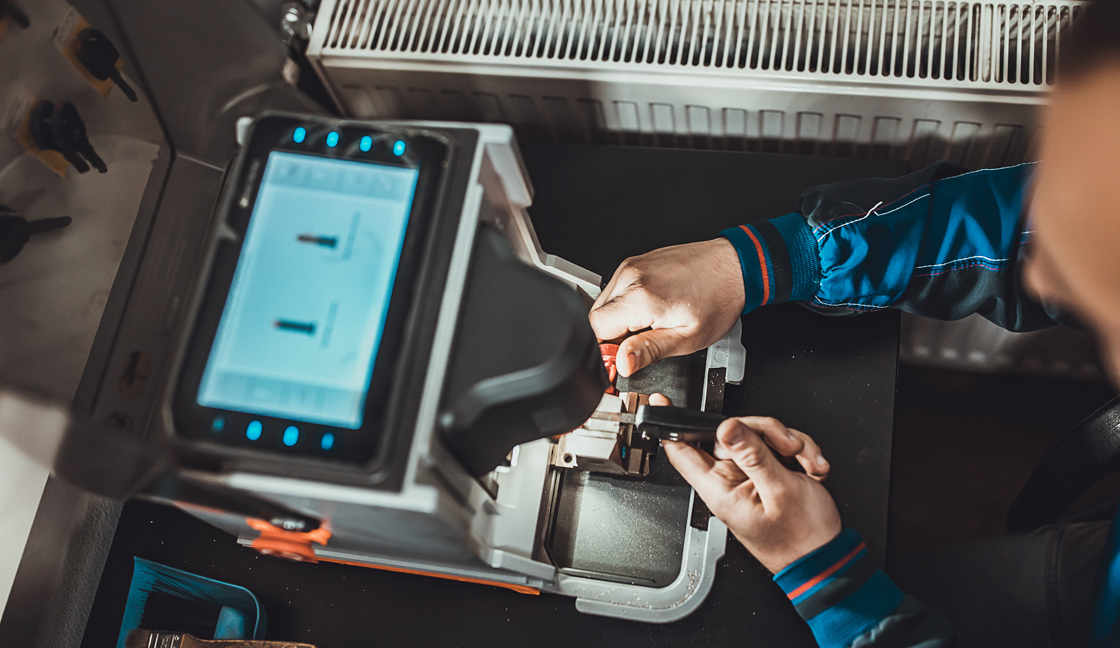 Man copying car key with key copy machine
