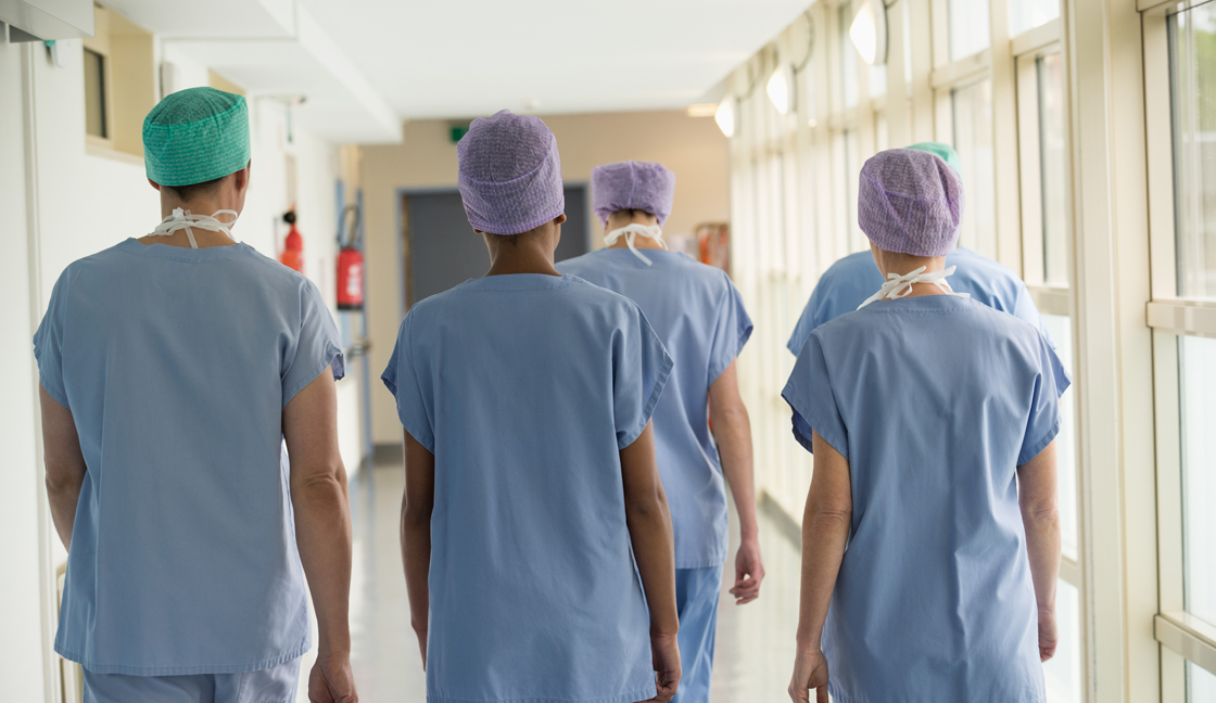 Rear view of a medical team walking in the corridor of a hospital