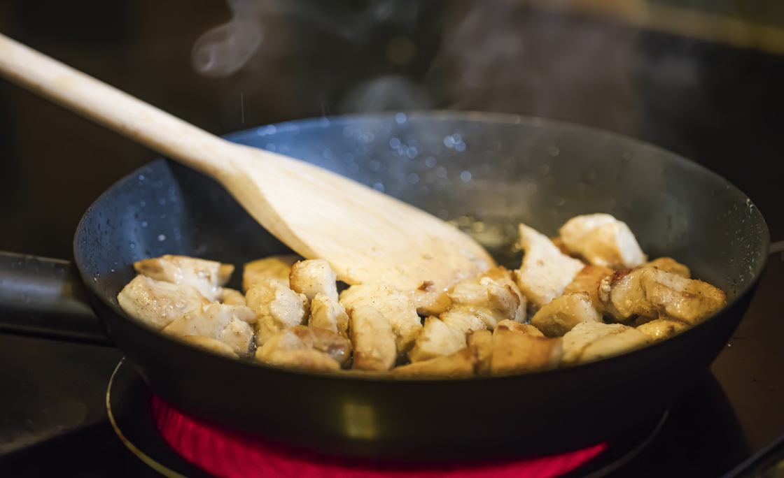 Chicken meat on frying pan on hot Electric Hob