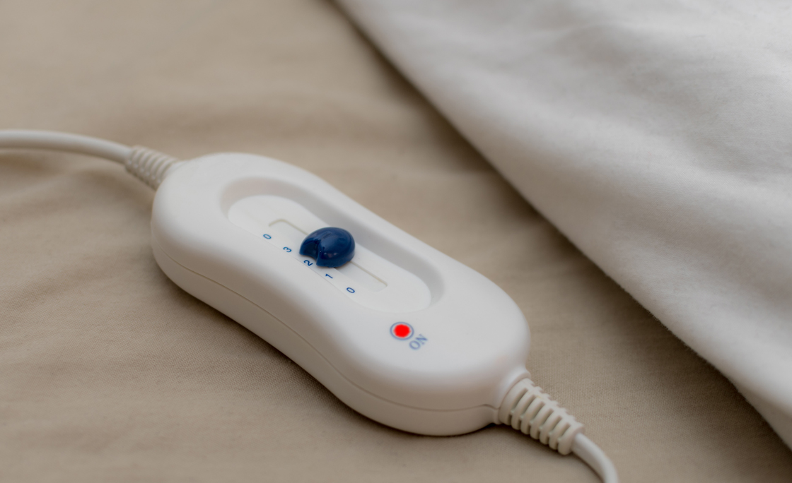 Control button for an electric blanket on a bed