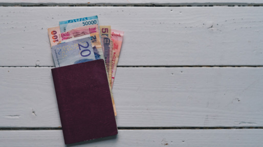 High Angle View Of Paper Currency And Passport On Table