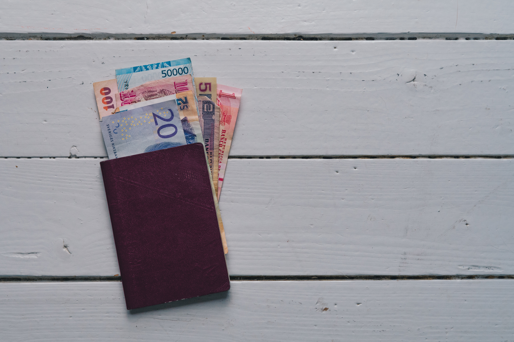 High Angle View Of Paper Currency And Passport On Table