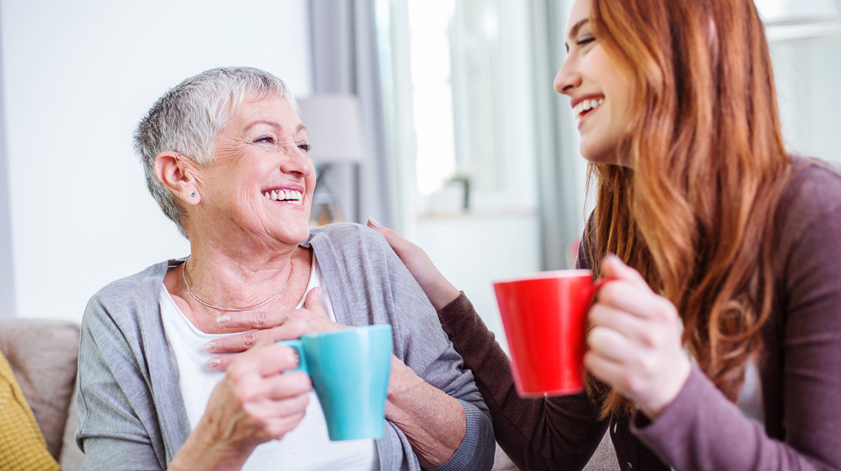 Mother and dauther having hot drinks together