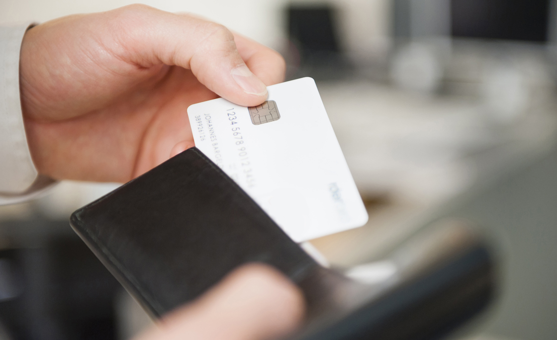 Hands of man holding wallet and blank white credit card