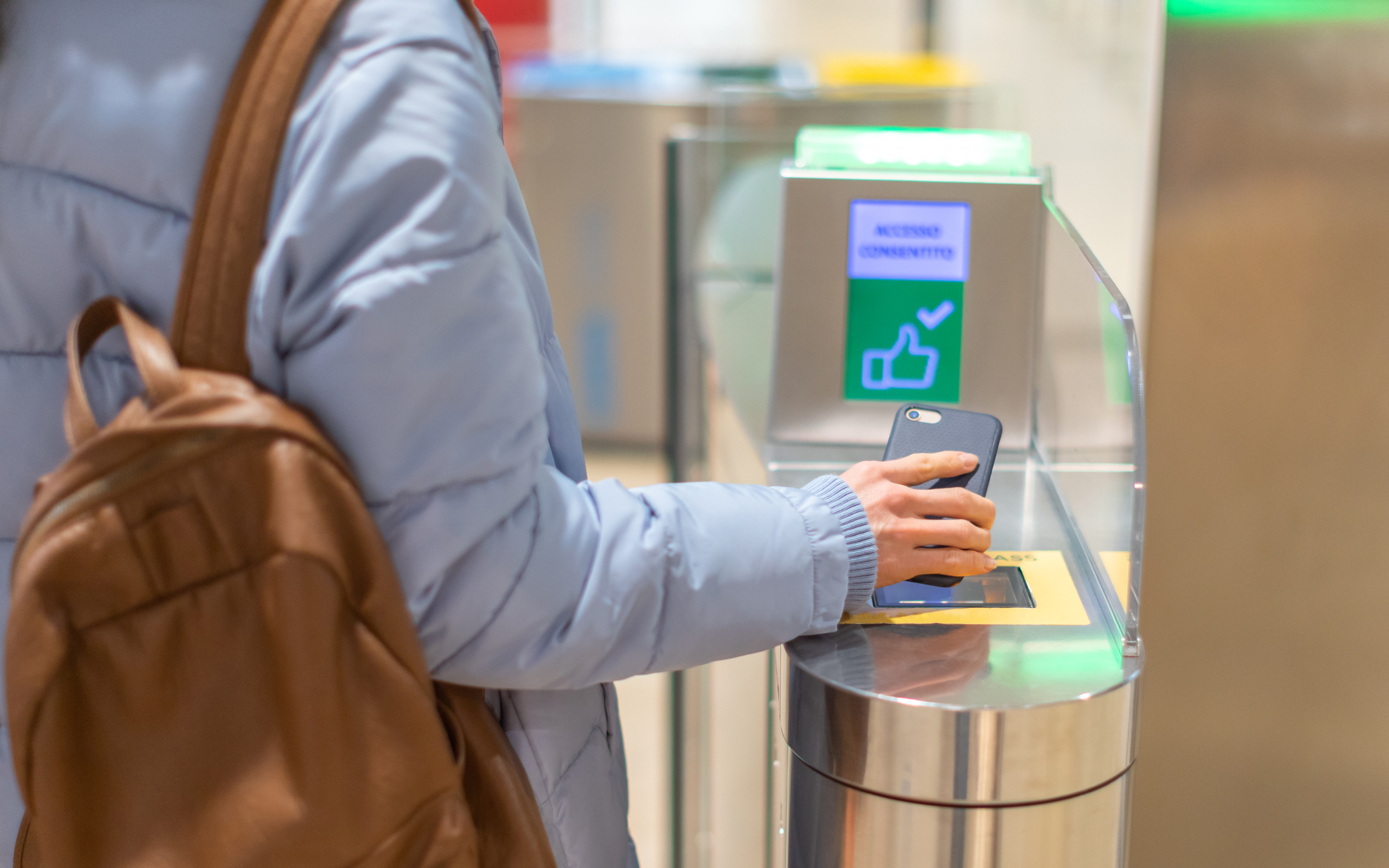 Electronic Boarding pass and passport control in the airport – hand with boarding pass on smartphone at the turnstile.