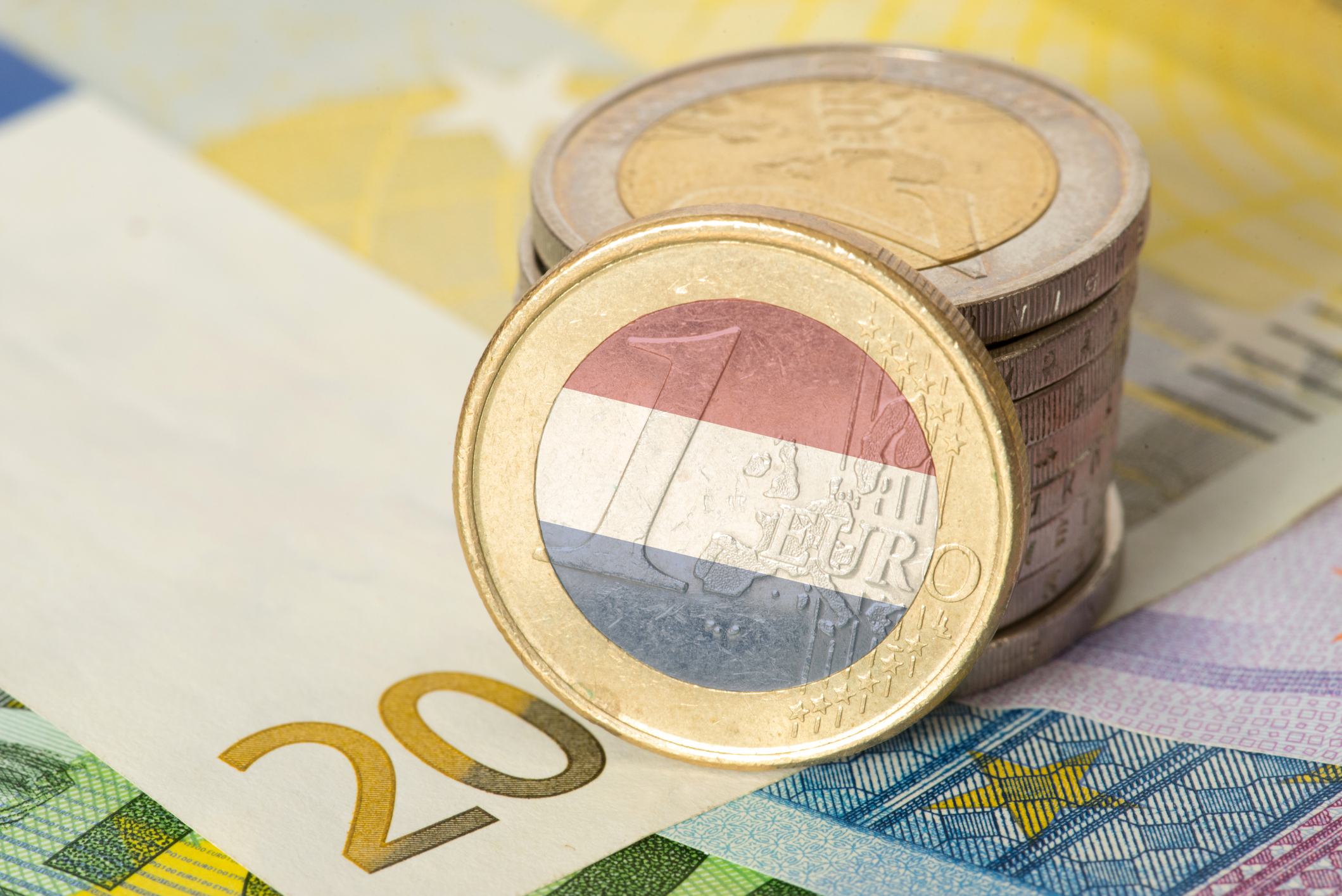 Euro notes and coins and flag of Holland