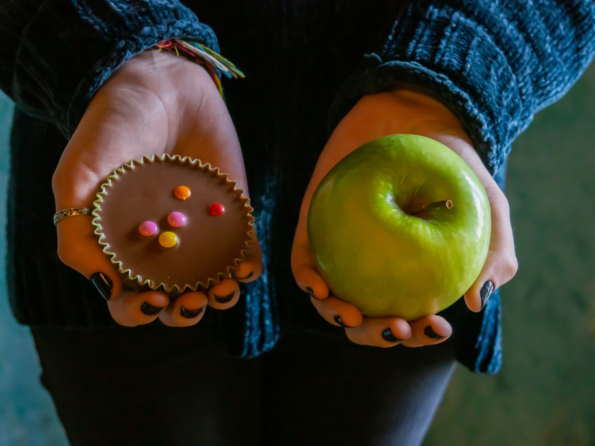 A person with a cupcake and an apple