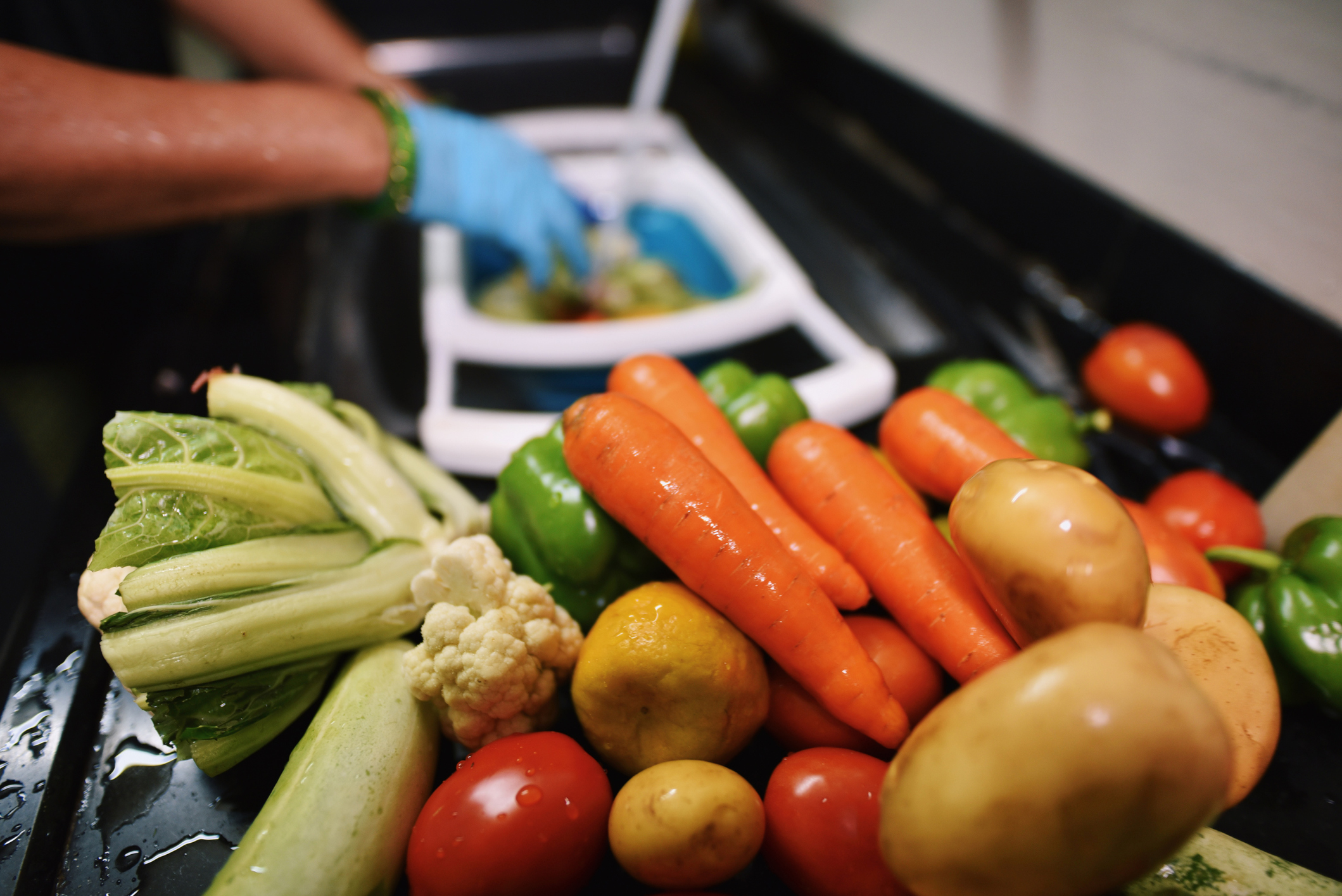 Cropped hands wearing protective gloves disinfecting groceries