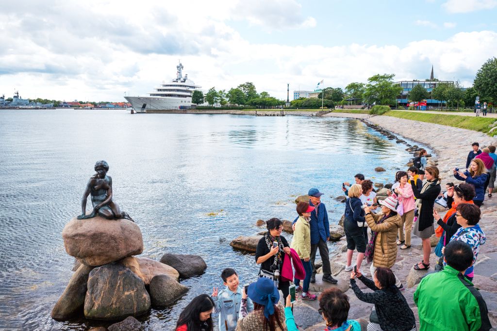 Copenhagen. Denmark. A crowd of tourists photographing the famous statue of the Little Mermaid