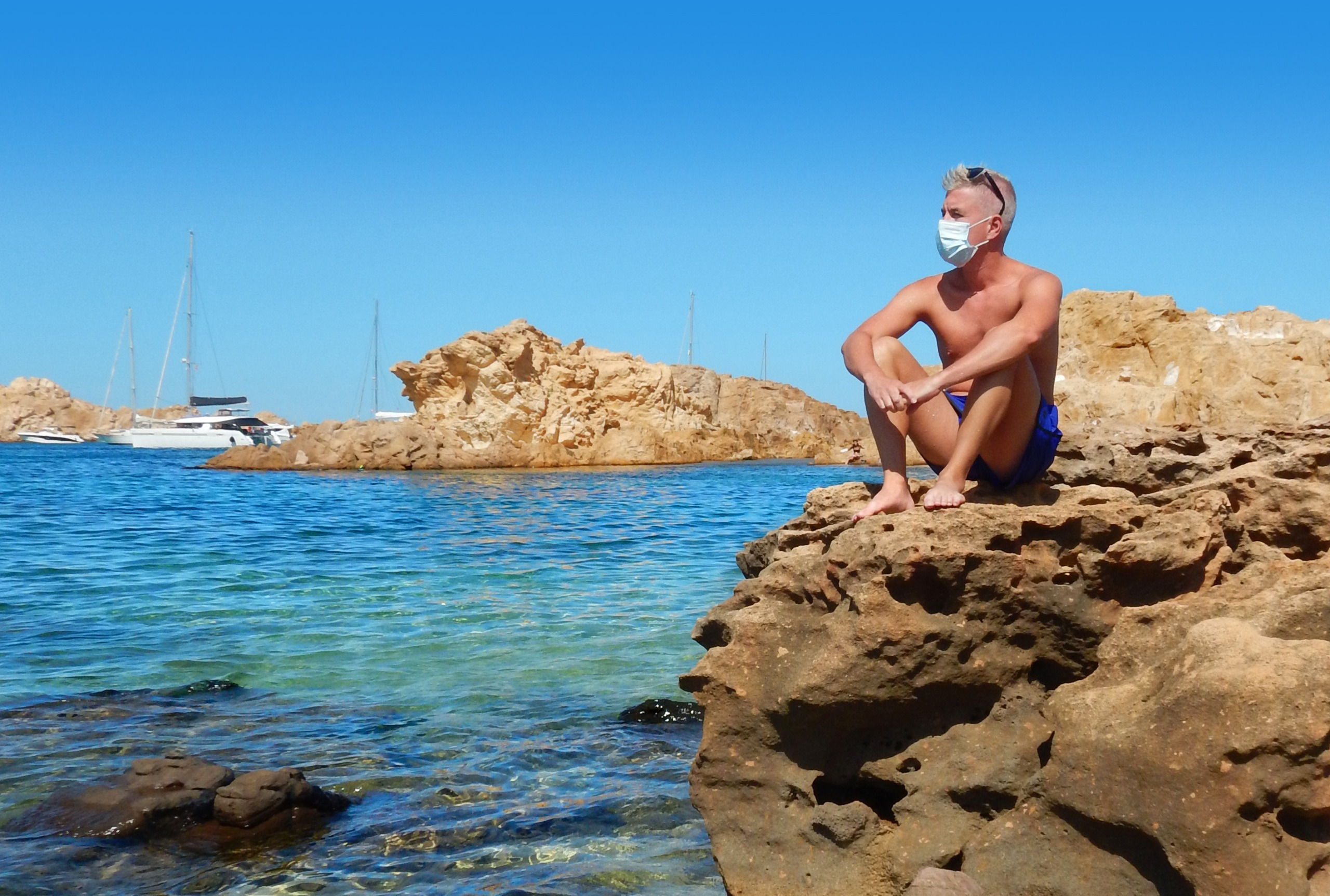Bather with a mask enjoys a day at the beach on the island of Menorca