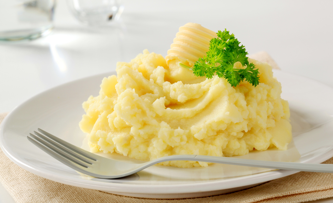 Close-up of mashed potatoes served on white ceramic plate