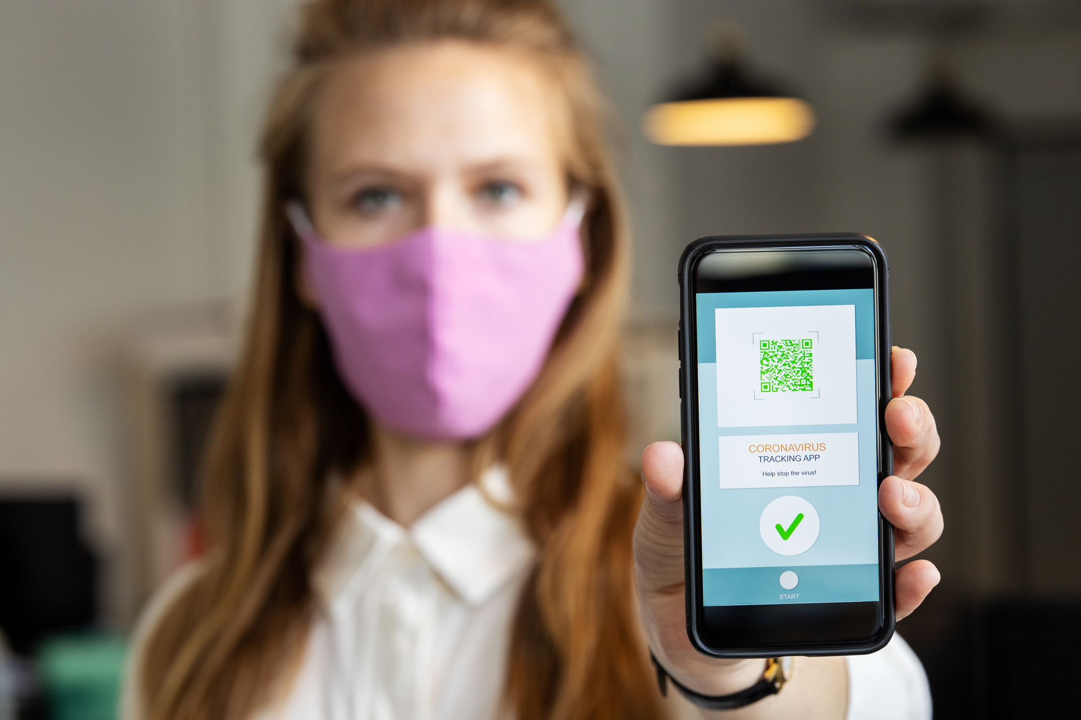 Businesswoman showing corona virus tracking app on her phone