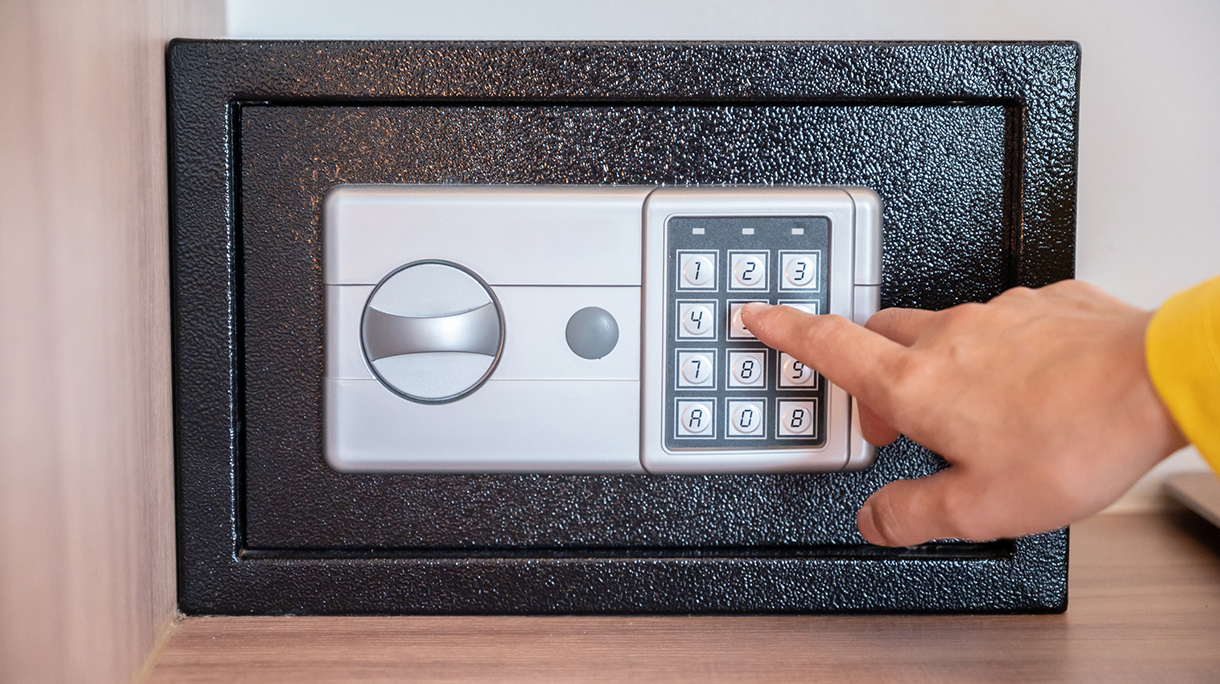 Someone hand trying to press passwords on safety lock pad for open a safety box.